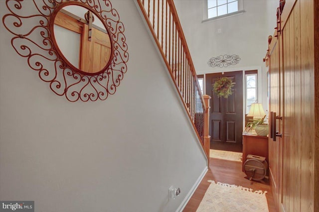 entrance foyer featuring hardwood / wood-style flooring and a towering ceiling