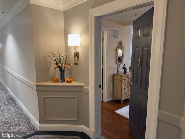 hall with ornamental molding and dark wood-type flooring