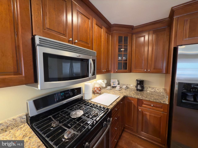 12251 Roundwood Rd Unit 601, Lutherville Timonium, MD 21093 - kitchen featuring appliances with stainless steel finishes, glass insert cabinets, light stone counters, and brown cabinets