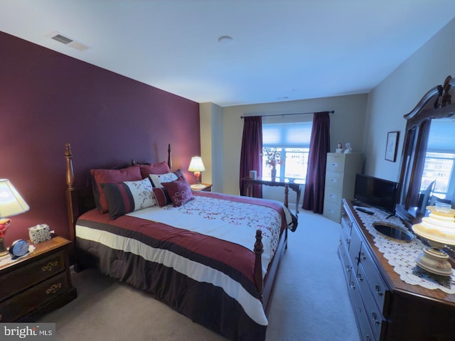 bedroom with light carpet and multiple windows