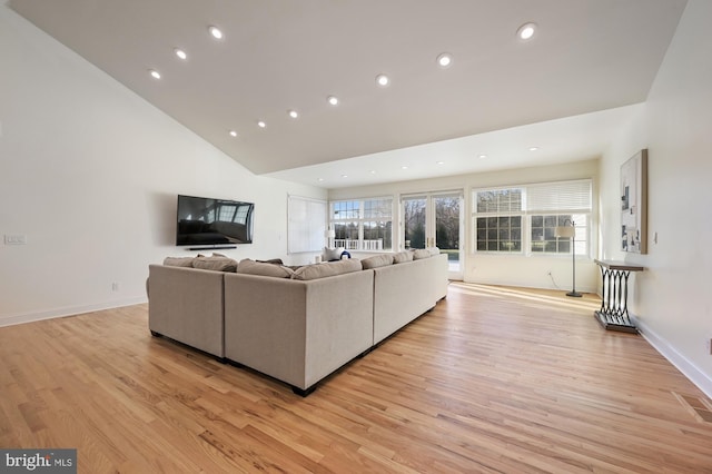 living room featuring light hardwood / wood-style floors and high vaulted ceiling