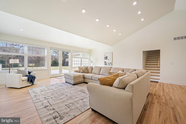 living room featuring light hardwood / wood-style floors and high vaulted ceiling