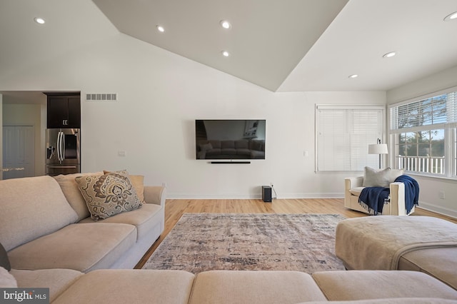 living room with light hardwood / wood-style floors and lofted ceiling