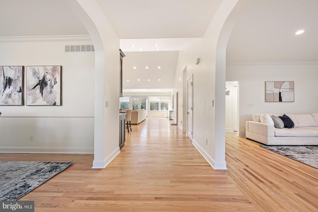 hall with crown molding and light hardwood / wood-style flooring