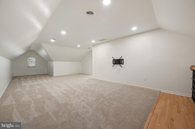 bonus room with light wood-type flooring and lofted ceiling