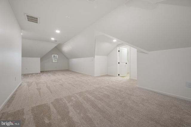 additional living space with light colored carpet and lofted ceiling