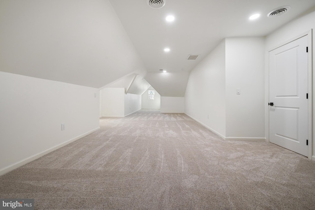 additional living space with light carpet and vaulted ceiling