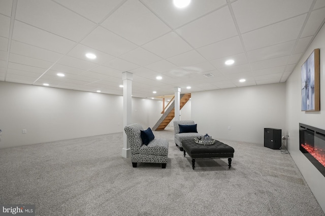 sitting room featuring a drop ceiling and carpet floors