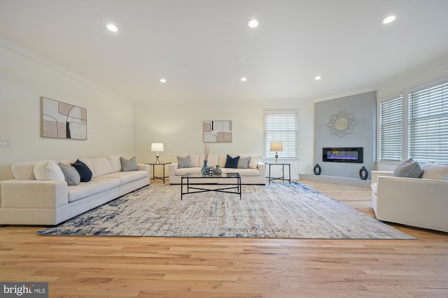 living room featuring light hardwood / wood-style flooring, a wealth of natural light, and ornamental molding