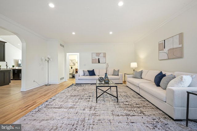 living room with hardwood / wood-style flooring and crown molding