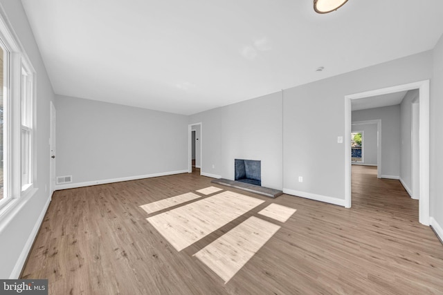 unfurnished living room with light hardwood / wood-style flooring and a wealth of natural light