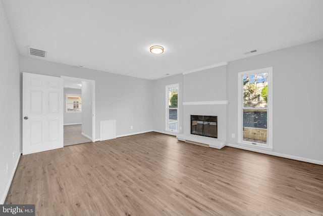 unfurnished living room with a wealth of natural light and light hardwood / wood-style floors