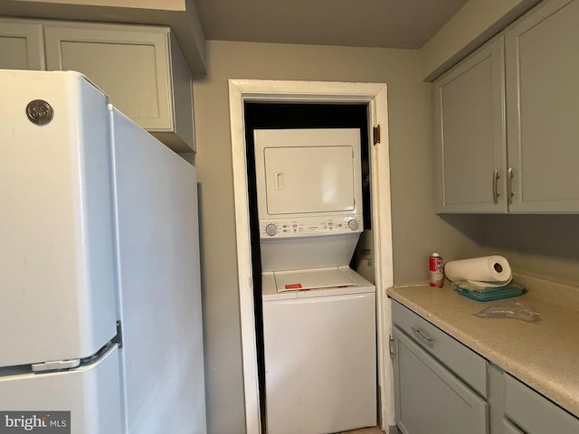 clothes washing area with stacked washer and dryer