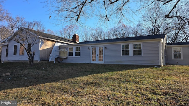 rear view of property featuring a lawn and french doors