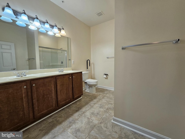 bathroom with vanity, toilet, and a shower with shower door