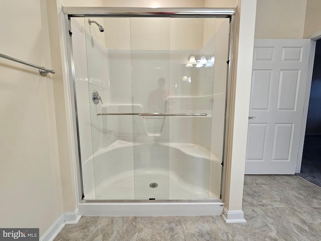 bathroom with a shower with door