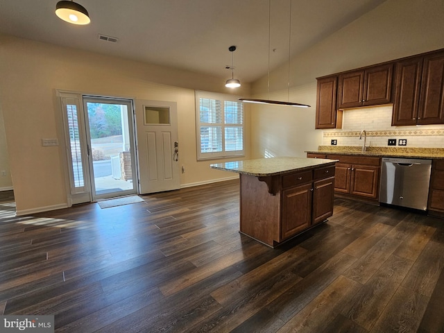 kitchen with dark wood-type flooring, decorative light fixtures, dishwasher, a kitchen island, and lofted ceiling