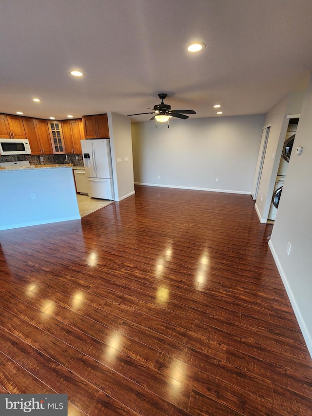 unfurnished living room featuring ceiling fan and dark hardwood / wood-style floors