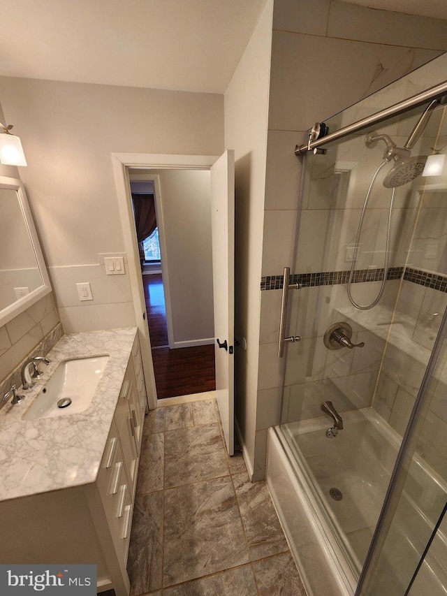 bathroom with hardwood / wood-style flooring, vanity, and combined bath / shower with glass door