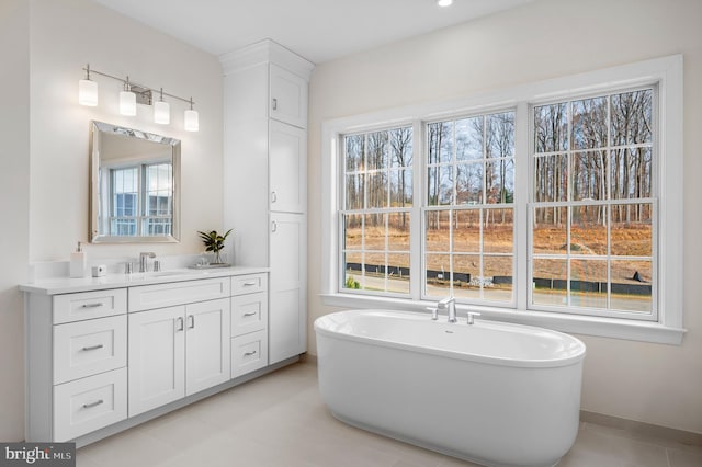 bathroom featuring tile patterned flooring, vanity, and a tub