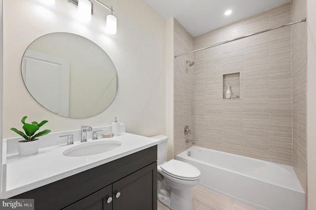 full bathroom with vanity, tiled shower / bath combo, and toilet