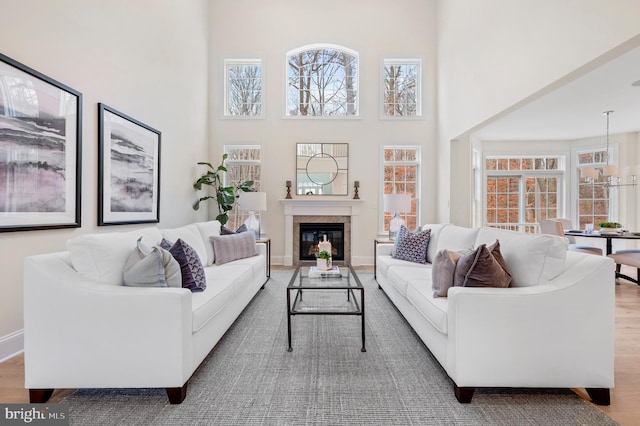 living room featuring hardwood / wood-style flooring, a notable chandelier, and a towering ceiling