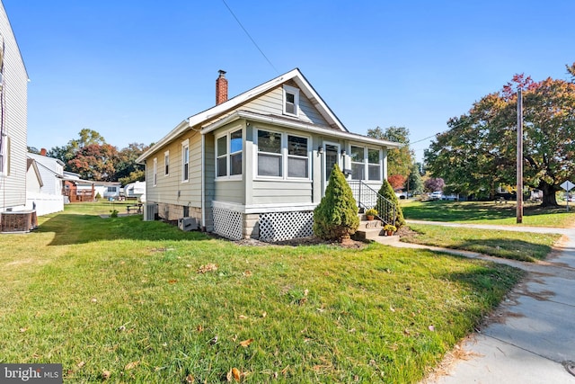 view of front of property with central AC and a front lawn