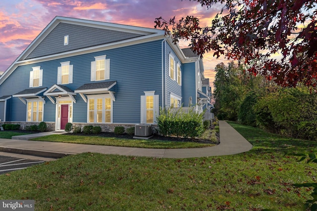 view of front of property with cooling unit and a lawn