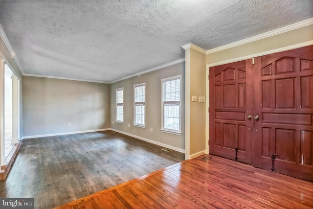 foyer with crown molding, dark wood-type flooring, and a textured ceiling