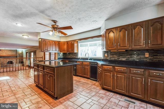 kitchen featuring tasteful backsplash, sink, a center island, ceiling fan, and a textured ceiling