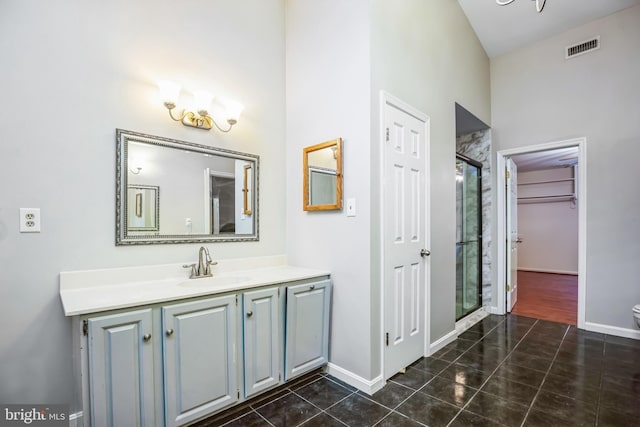 bathroom with vanity, toilet, an enclosed shower, and tile patterned flooring