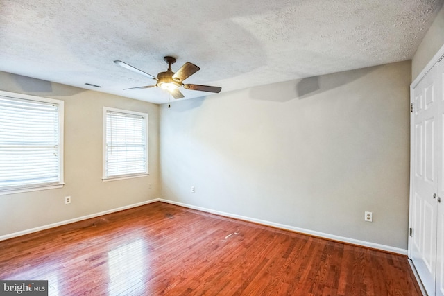 unfurnished room featuring ceiling fan, hardwood / wood-style floors, and a textured ceiling