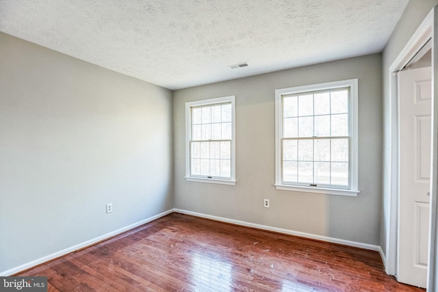 spare room with wood-type flooring and a textured ceiling