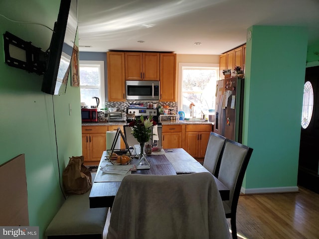 kitchen with decorative backsplash, wood-type flooring, stainless steel appliances, and a wealth of natural light