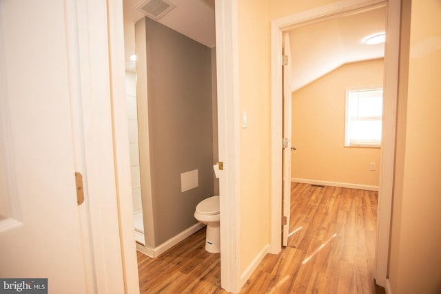 bathroom with toilet, wood-type flooring, and vaulted ceiling