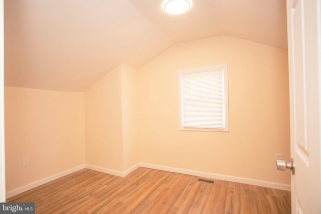 additional living space featuring hardwood / wood-style flooring and lofted ceiling