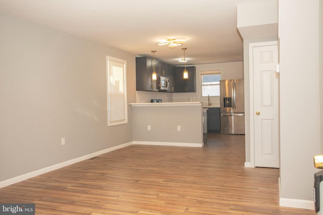 unfurnished living room with sink and light hardwood / wood-style floors