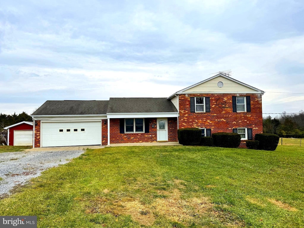 split level home featuring a front yard, brick siding, and driveway