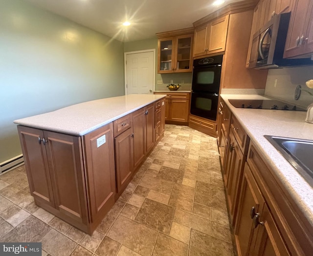 kitchen featuring black appliances, a center island, and baseboard heating