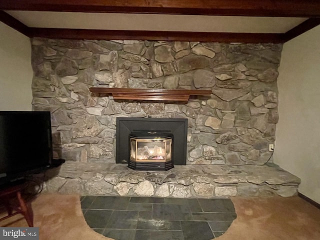 details featuring beamed ceiling and a wood stove