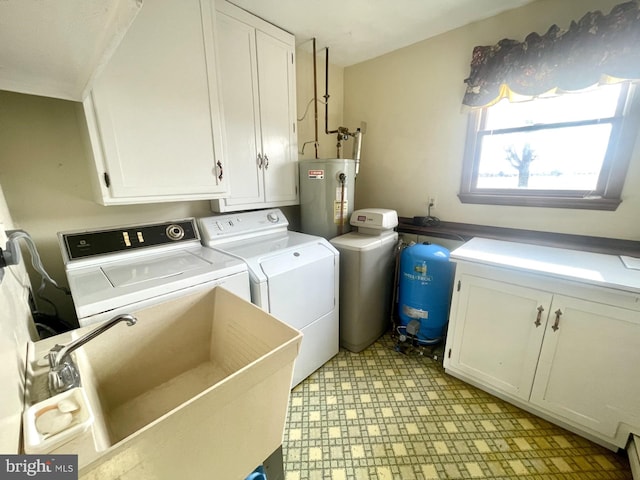 clothes washing area with cabinets, sink, washer and dryer, and gas water heater