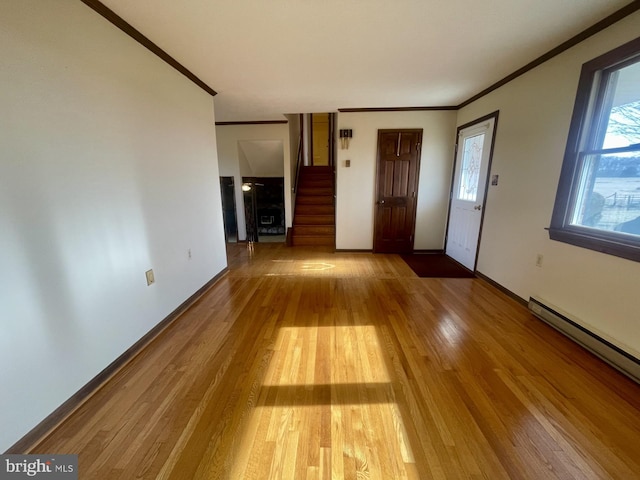 unfurnished living room featuring a baseboard radiator, ornamental molding, and light wood-type flooring