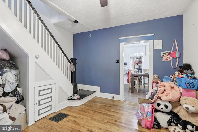 entryway featuring hardwood / wood-style flooring, a textured ceiling, and a chandelier