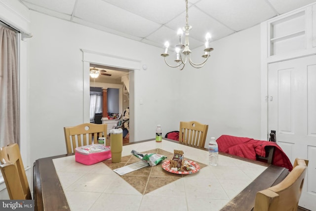 tiled dining room featuring a paneled ceiling and ceiling fan with notable chandelier