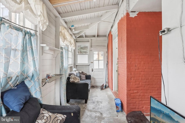 interior space featuring concrete flooring and brick wall