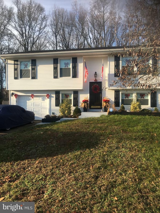 bi-level home with a garage and a front lawn