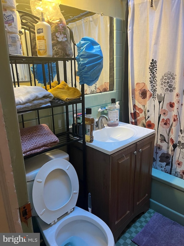 full bathroom with vanity, shower / bath combo, and toilet