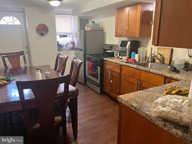 kitchen featuring dark hardwood / wood-style floors, sink, light stone countertops, and stainless steel appliances