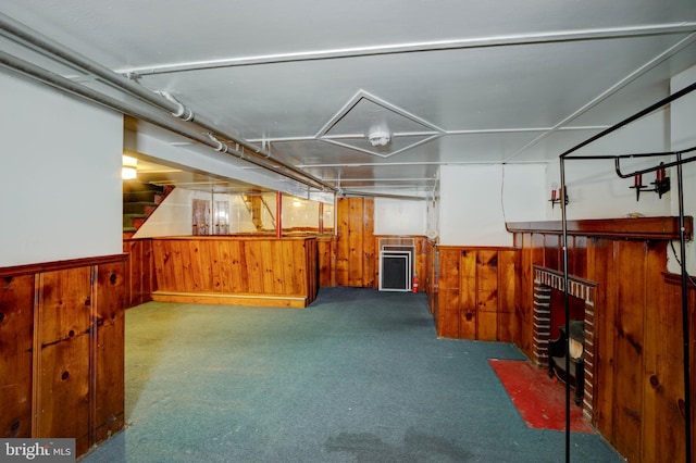 basement featuring wooden walls and carpet