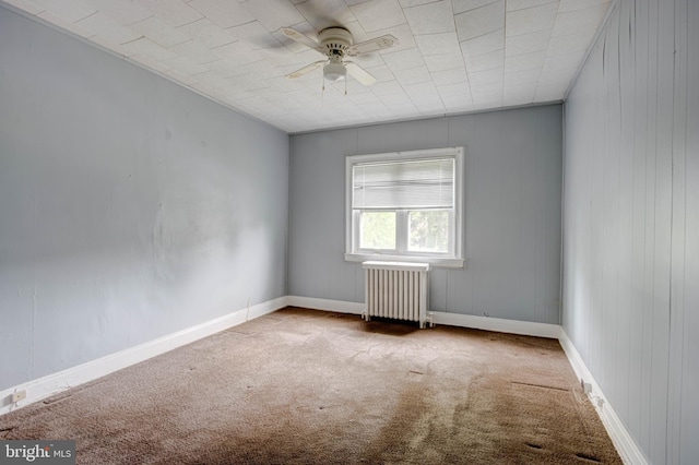 carpeted spare room with ceiling fan and radiator heating unit